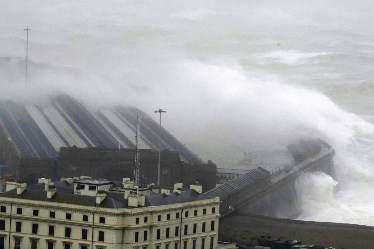 Waves crashing over the harbor wall in Folkestone, southern England