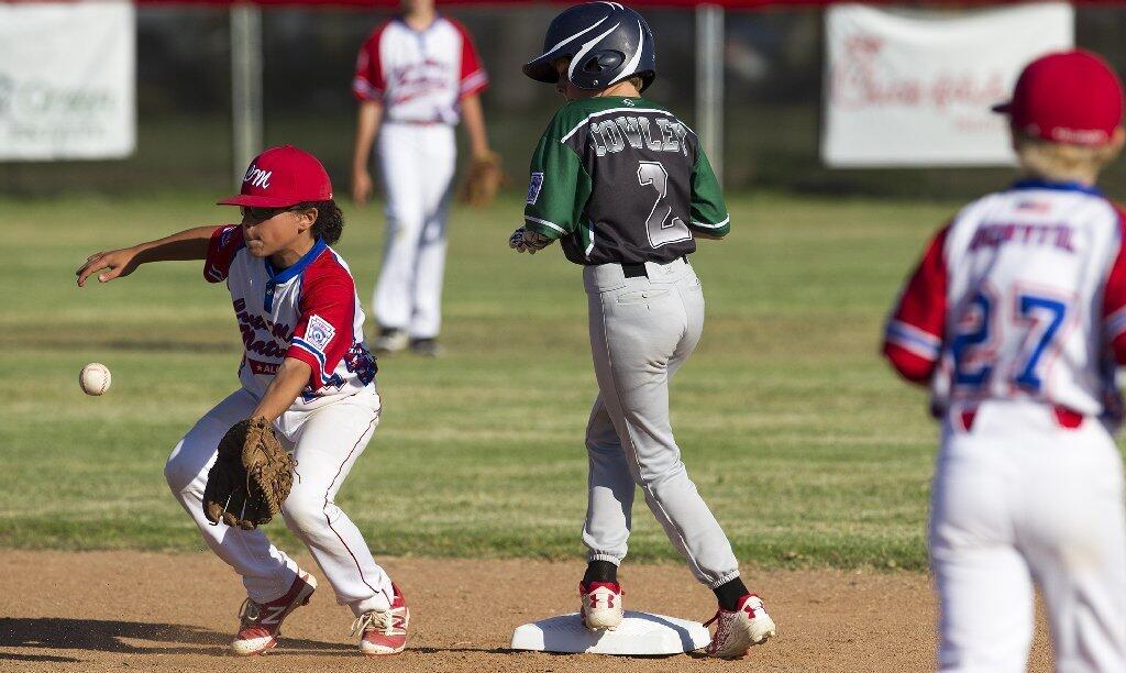 Costa Mesa American Little League's Kyle Cowley is safe at second as Costa Mesa National Little League's Dimitri Susidko attempts to field the throw during game two of the Mayor's Cup series on Monday.
