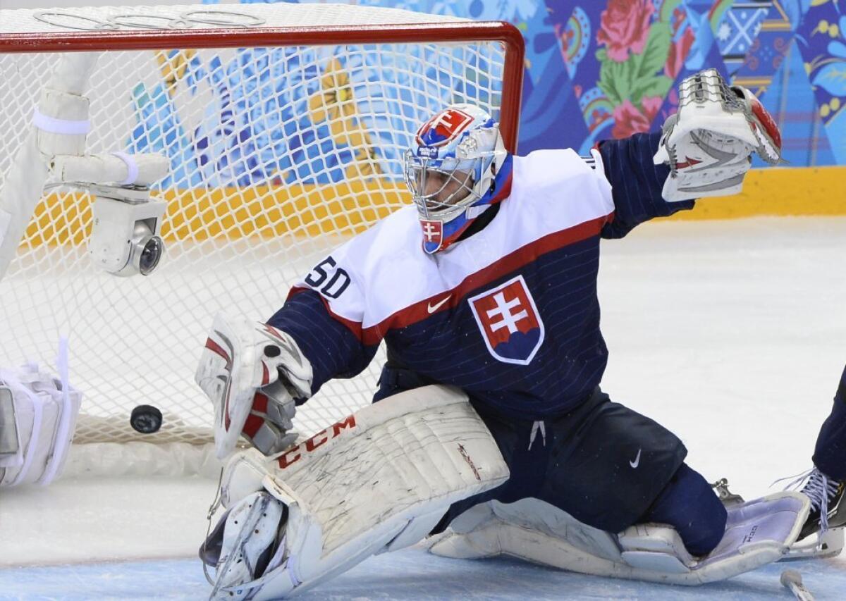 Slovakia goalie Jan Laco fails to stop a shot by the Czech Republic's Ales Hemsky during the men's hockey quarterfinals at the Sochi Olympics.