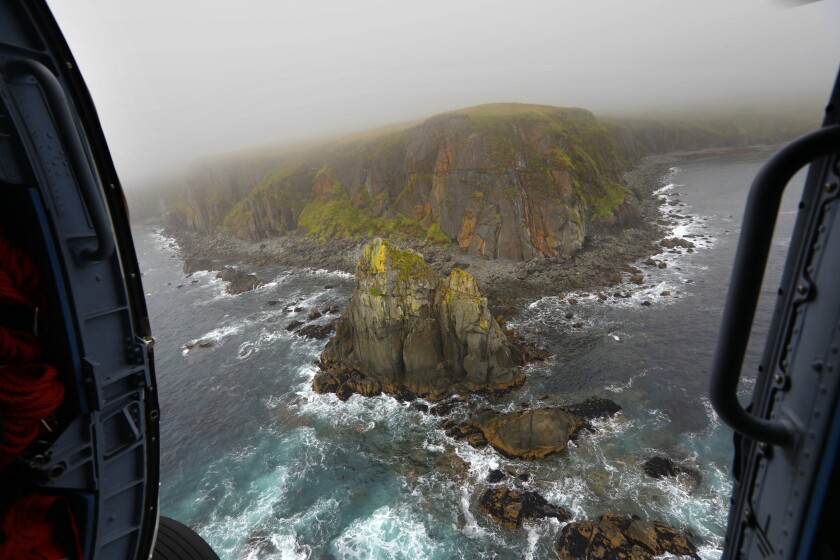 Rocky coastal terrain seen from a helicopter