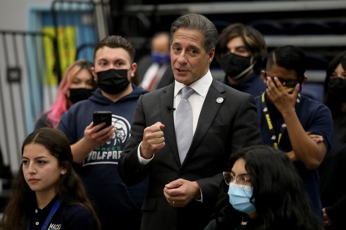 L.A. schools chief Alberto Carvalho pumps his fist surrounded by students. 