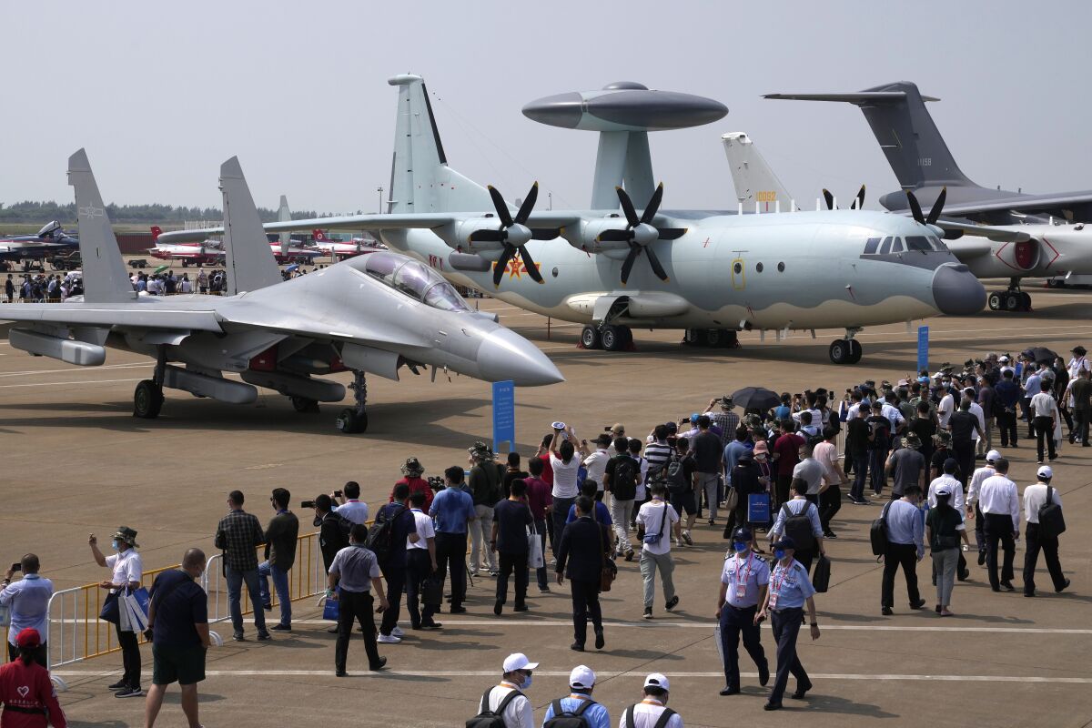 FILE - Visitors view the Chinese military's J-16D electronic warfare airplane, left, and the KJ-500 airborne early warning and control aircraft at right during 13th China International Aviation and Aerospace Exhibition, also known as Airshow China 2021, Wednesday, Sept. 29, 2021, in Zhuhai, China. China's Defense Ministry announced Tuesday, Nov. 10. 2021, that its military forces are holding exercises near Taiwan in response to a visit by a U.S. Congressional delegation to the island. (AP Photo/Ng Han Guan, File)