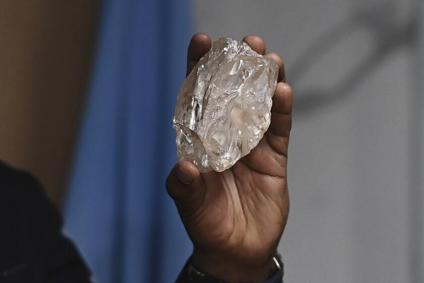 Una persona sostiene un diamante de 2.492 quilates que fue encontrado en el país y está en exhibición, el jueves 22 de agosto de 2024, en Gaborone, Botsuana. (AP Foto)