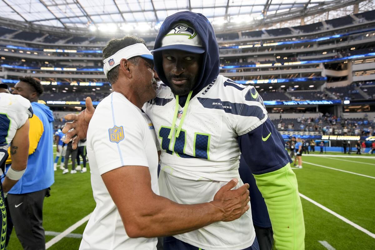 DK Metcalf des Seahawks serre dans ses bras l'entraîneur des receveurs des Chargers, Sanjay Lal, l'ancien entraîneur du receveur à Seattle.