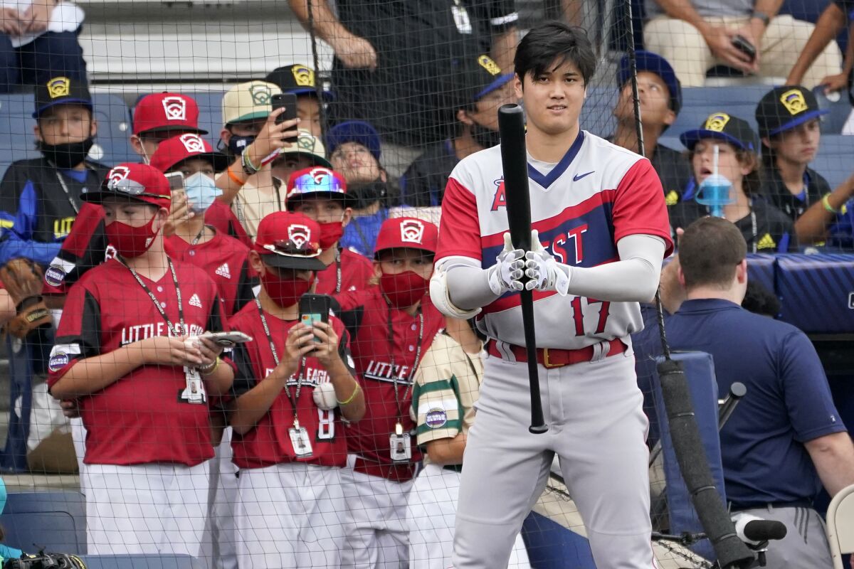 Angels star Shohei Ohtani warms up as Little Leaguers from Hamilton, Ohio, in red, watch 