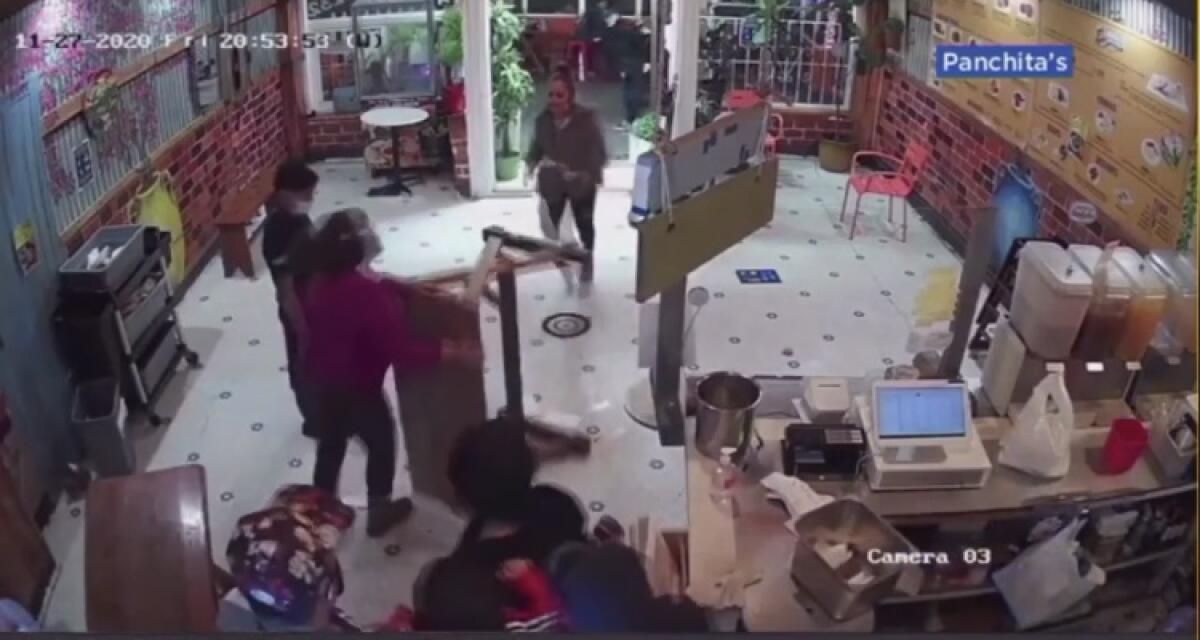 En esta imagen se observa a Doris Campos (camisa ocre) empujar una mesa en contra de una mujer agresiva.