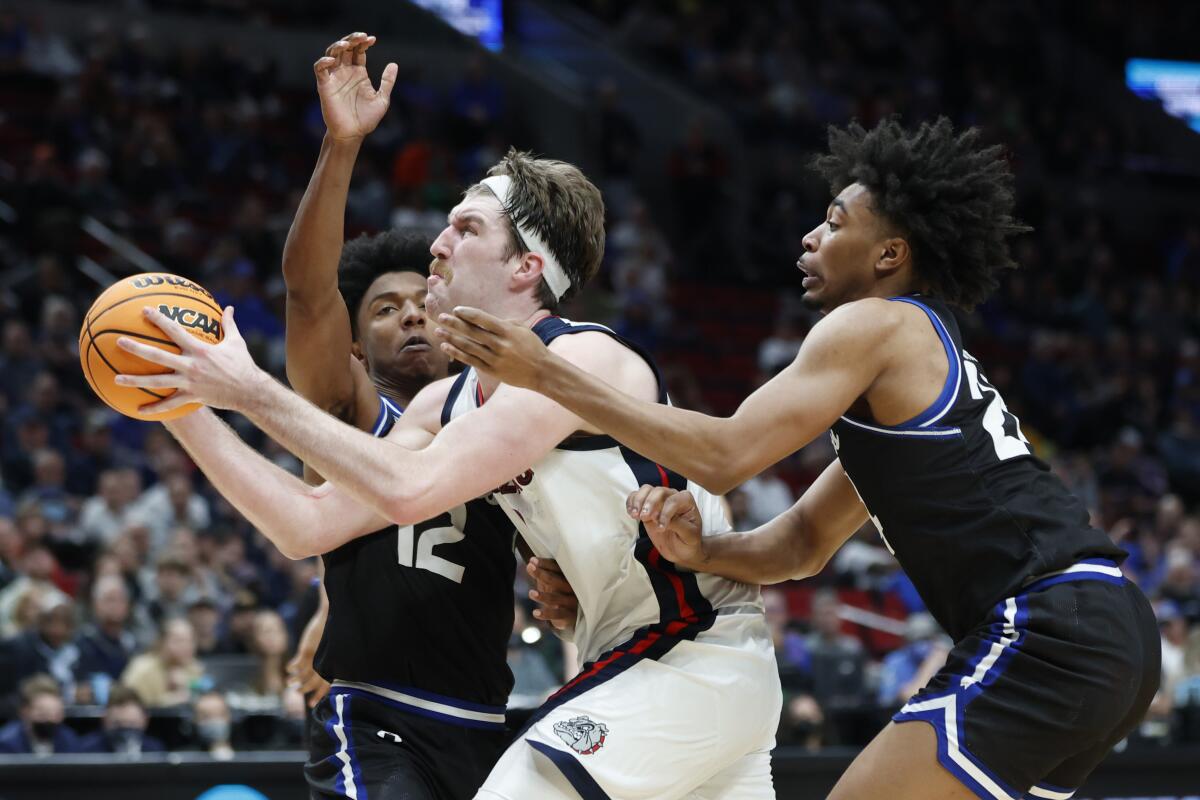 Gonzaga's Drew Timme drives between Georgia State's Kane Williams (12) and Collin Moore.