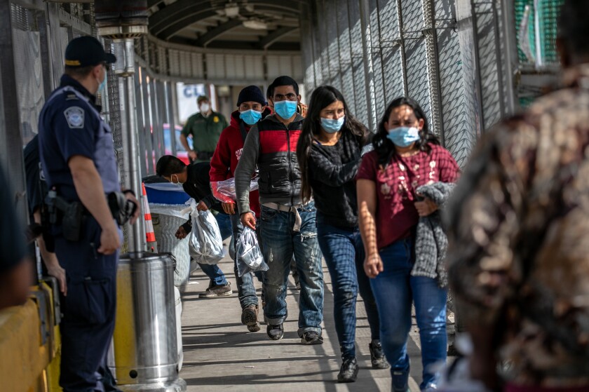 Deportees walk across the U.S.-Mexico border bridge from Brownsville, Texas to Matamoros, Mexico, on Feb. 23. 