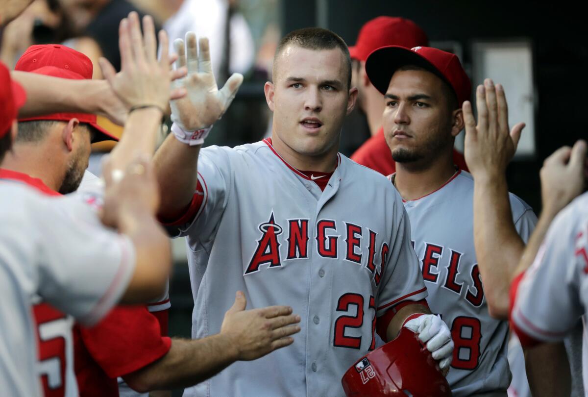 Angels outfielder Mike Trout high-fives teammates in the dugout after scoring in the first inning against the Baltimore Orioles on Friday.