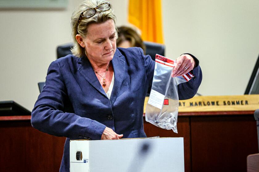 Special prosecutor Kari Morrissey looks through a box of evidence to present to crime scene technician Marissa Poppell during question in Judge Mary Marlowe Sommer's courtroom at the First Judicial District Courthouse in Santa Fe, NM on Friday, Feb.23, 2024.