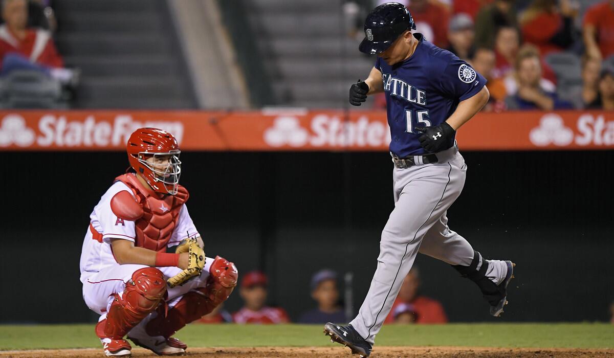 Seattle Mariners' Kyle Seager, right, scores after hitting a solo home run as Angels catcher Juan Graterol watches during the fifth inning on Wednesday.