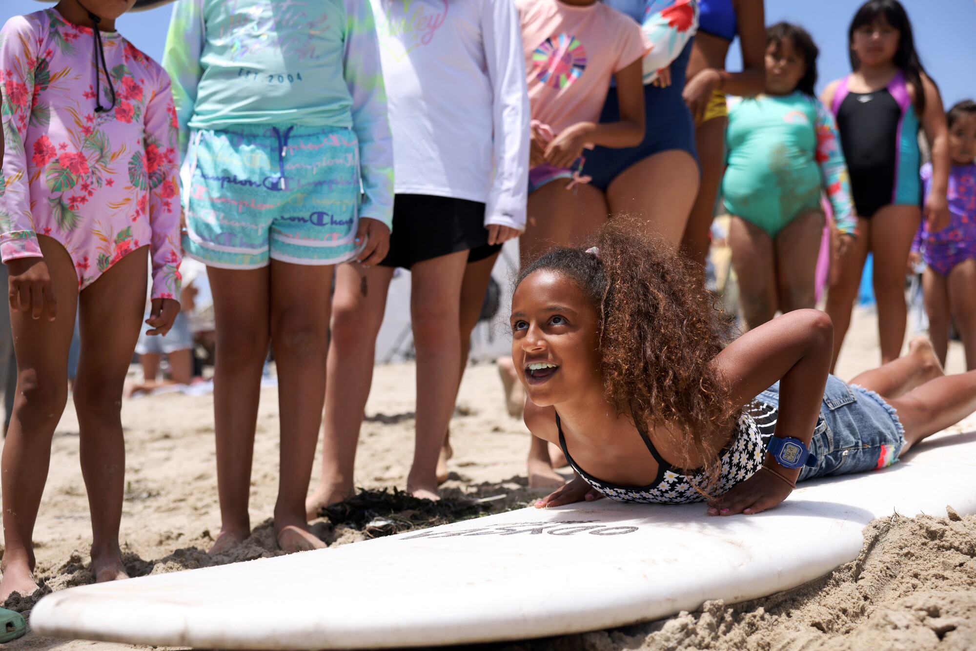 Mila Jituboh prend des conseils d'un instructeur sur la façon de surfer à First Point à Malibu.