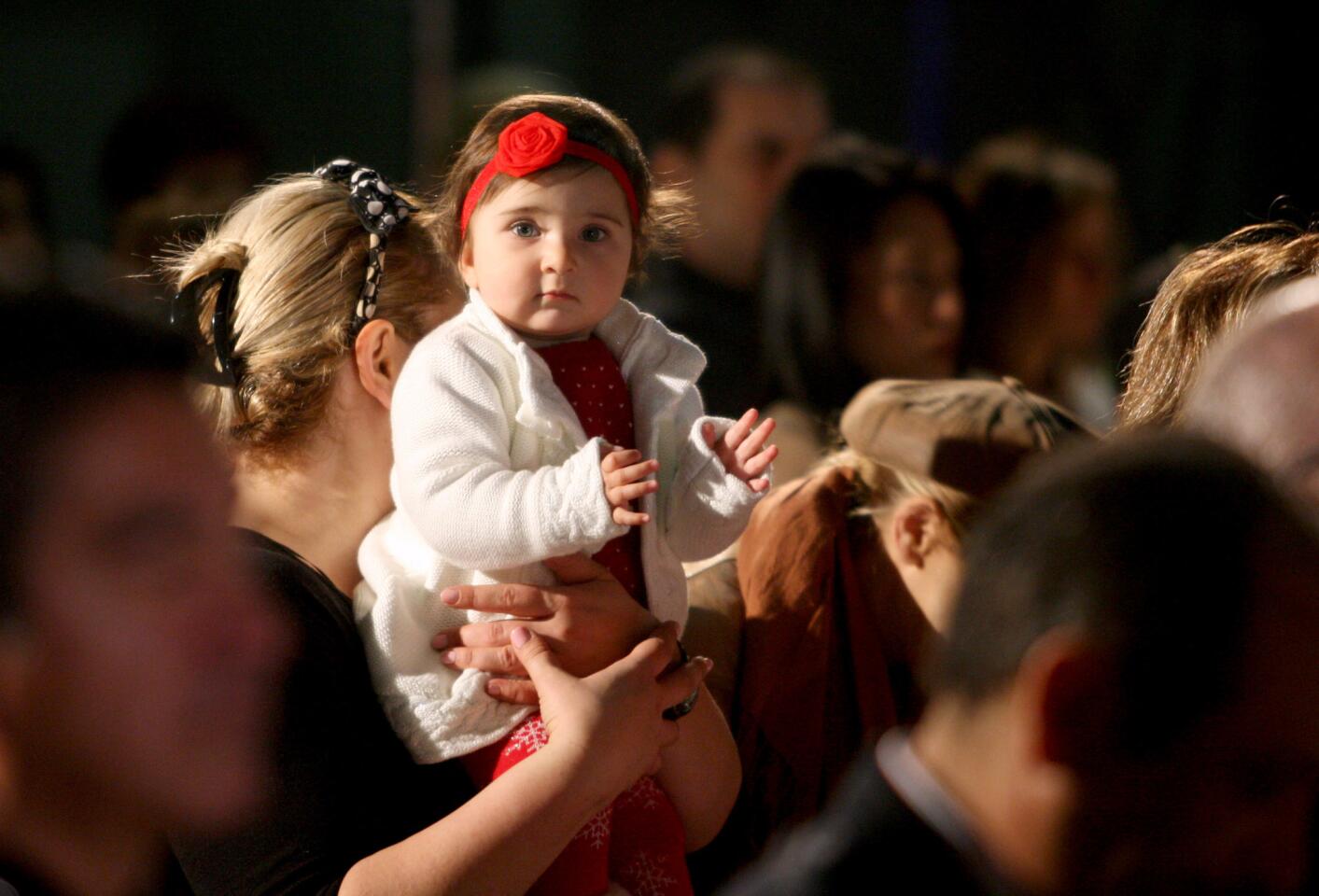A little child enjoys Christmas songs at the tree lighting ceremony at Perkins Plaza in Glendale on Wednesday, Dec. 2, 2015.