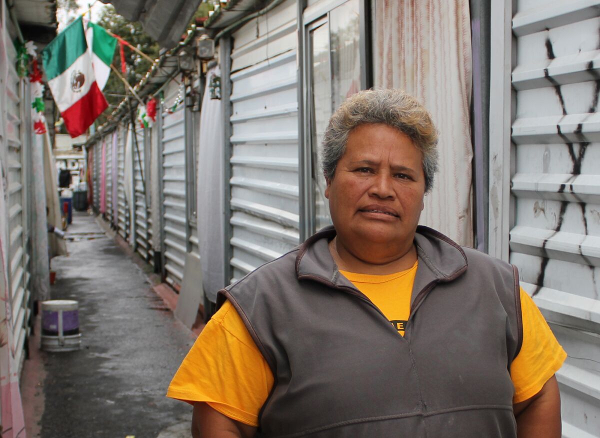 Marcia Vasquez stands outside her tin shack in one of five temporary camps for victims of the 1985 Mexico City earthquake where the residents are still living 30 years later.