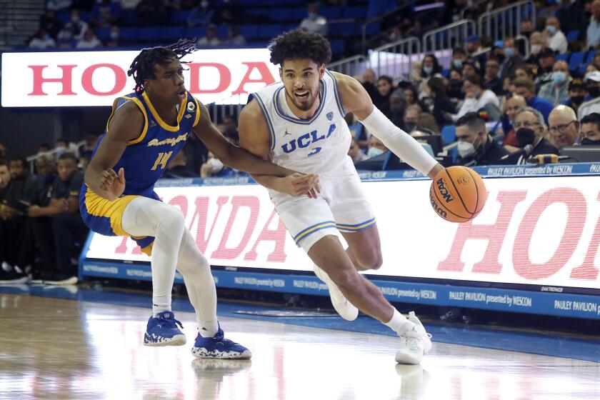 UCLA guard Johnny Juzang, right, drives past Cal State Bakersfield guard Kaleb Higgins during the second half of an NCAA college basketball game Tuesday, Nov. 9, 2021, in Los Angeles. UCLA won 95-58. (AP Photo/Ringo H.W. Chiu)