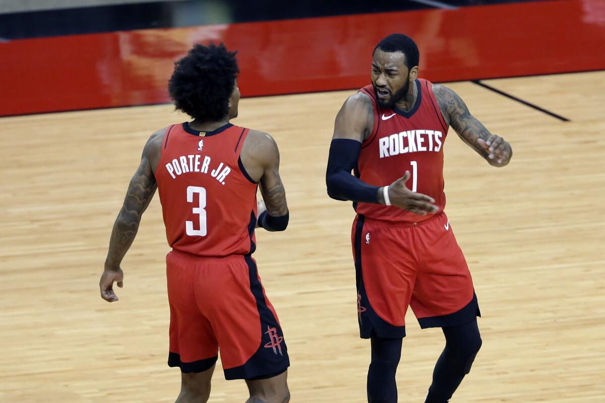 Houston Rockets guard Kevin Porter Jr. (3) and guard John Wall (1) celebrate after Wall scored in the final minute of the team's NBA basketball game against the Dallas Mavericks on Wednesday, April 7, 2021, in Houston. (AP Photo/Michael Wyke, Pool)