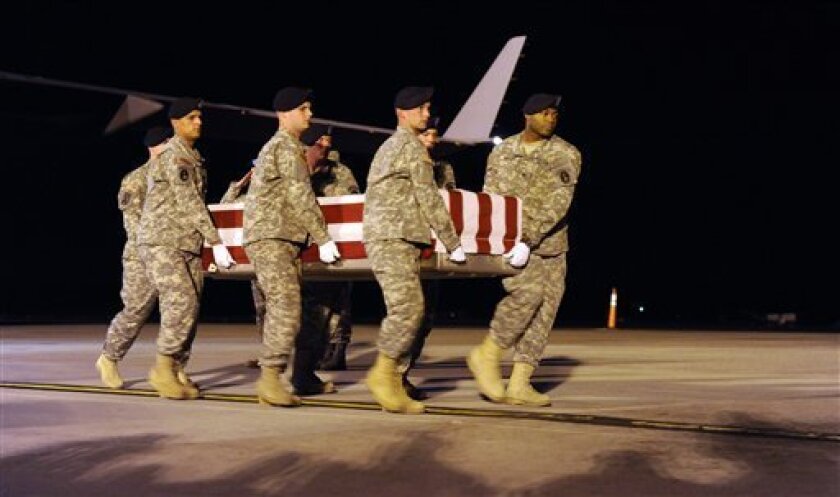 A carry team carries the transfer case containing the remains of Army Specialist Israel Candelaria Mejias of San Lorenzo, Puerto Rico, who died in Operation Iraqi Freedom, during the dignified transfer event at Dover Air Force Base, Del., Tuesday, April 7, 2009. (AP Photo/Susan Walsh)