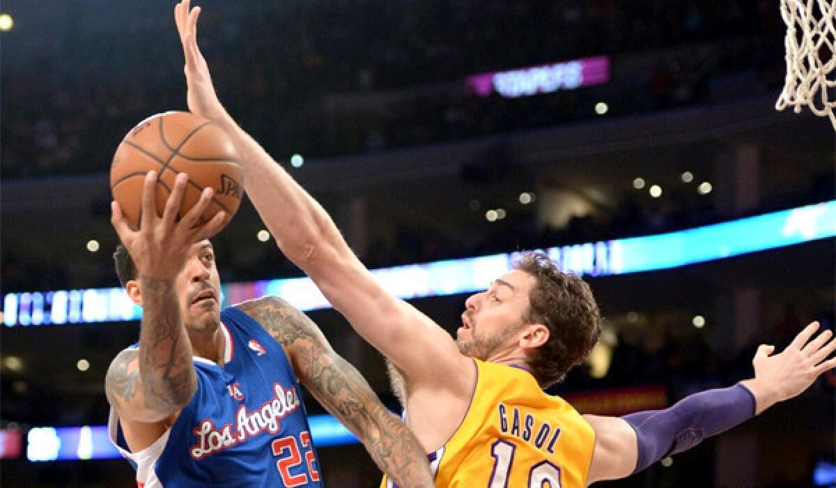 Matt Barnes maneuvers around Pau Gasol during the first half of the Clippers' matchup with the Lakers on Thursday at Staples Center.