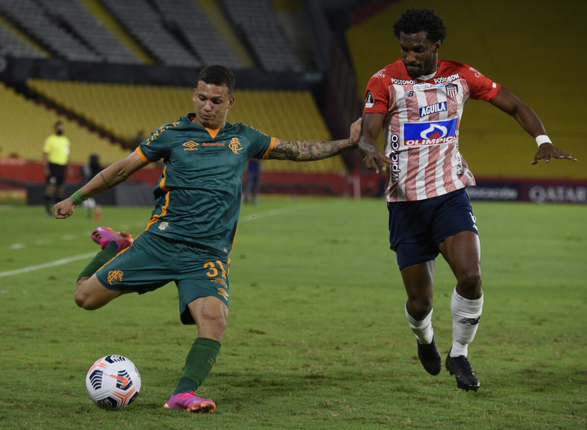 Lucas Calegari of Brazil's Fluminense, left, kicks the ball in front of Didier Moreno of Colombia's Junior.