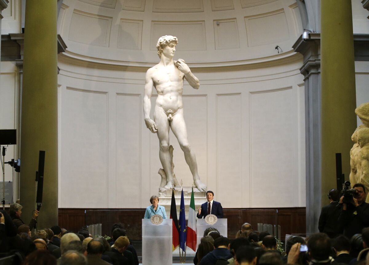 FILE - German Chancellor Angela Merkel, left, and Italian Prime Minister Matteo Renzi speak during a press conference in front of Michelangelo's "David statue" after their bilateral summit in Florence, Italy, on Jan. 23, 2015. The head of Florence’s Galleria del’Accademia on Sunday March 26, 2023 invited the parents and students of a Florida charter school to visit and see Michelangelo’s “David,” after the school principal was forced to resign following parental complaints that an image of the nude Renaissance masterpiece was shown to a sixth-grade art class. (AP Photo/Antonio Calanni, File)