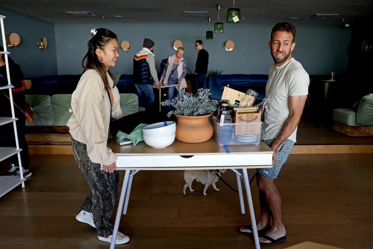 Two people move a table filled with plants and other items at the Wing in West Hollywood on March 25. 