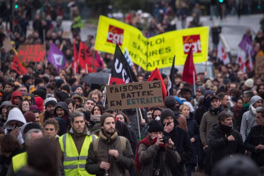 People hold signs and wave flags during a demonstration on December 10, 2019 in Nantes as part of the sixth day of massive strike action over government's plans to overhaul the pension system. - French unions have vowed to keep up the fight over the reforms, which are set to be finalised and published on December 11, with mass demonstrations in Paris and other cities, with teachers and other workers who once again have walked out alongside transport workers. (Photo by Loic VENANCE / AFP) (Photo by LOIC VENANCE/AFP via Getty Images) ** OUTS - ELSENT, FPG, CM - OUTS * NM, PH, VA if sourced by CT, LA or MoD **