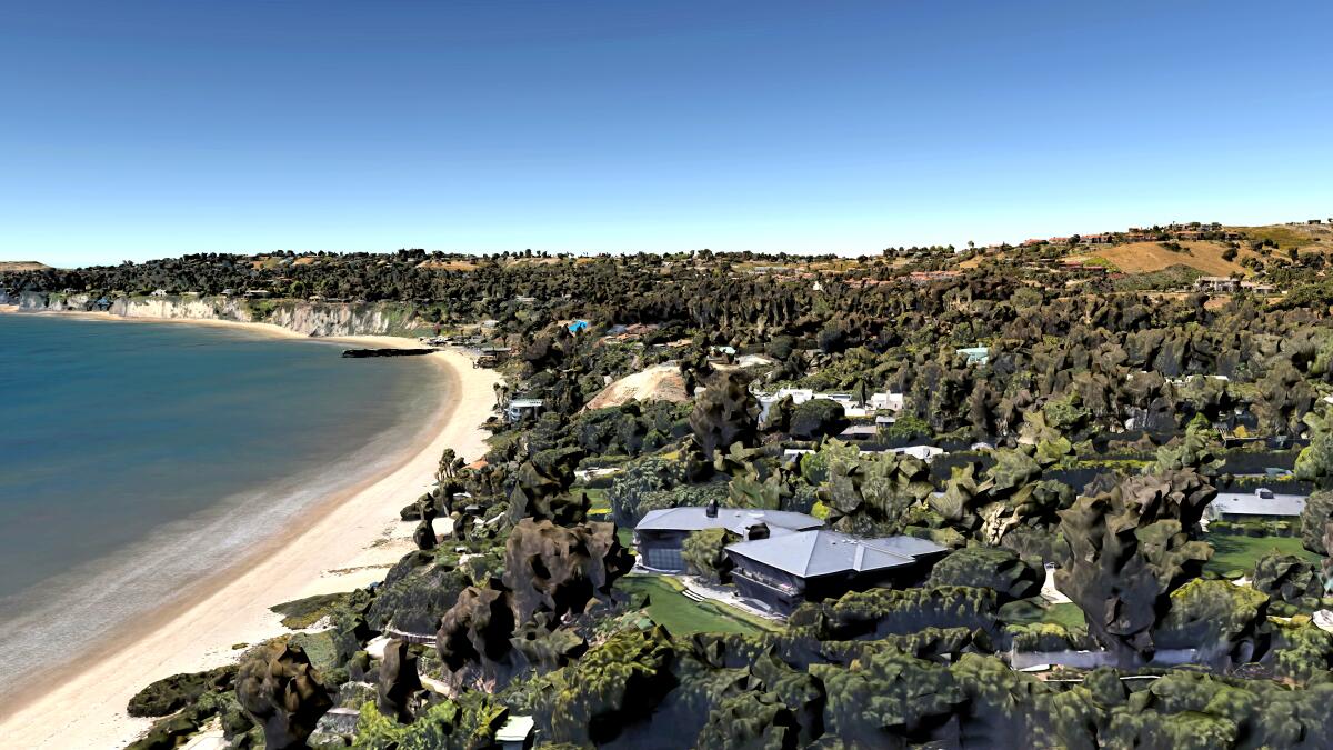 A mansion on a hill overlooks the ocean to the left