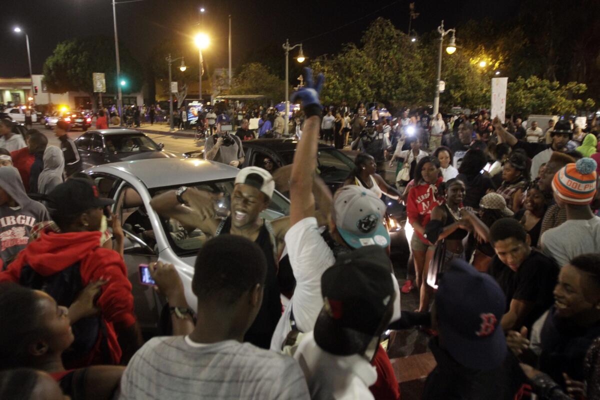 Hundreds of youths join in as protesters stop traffic at the intersection of Crenshaw Boulevard and Vernon Avenue on Monday night.