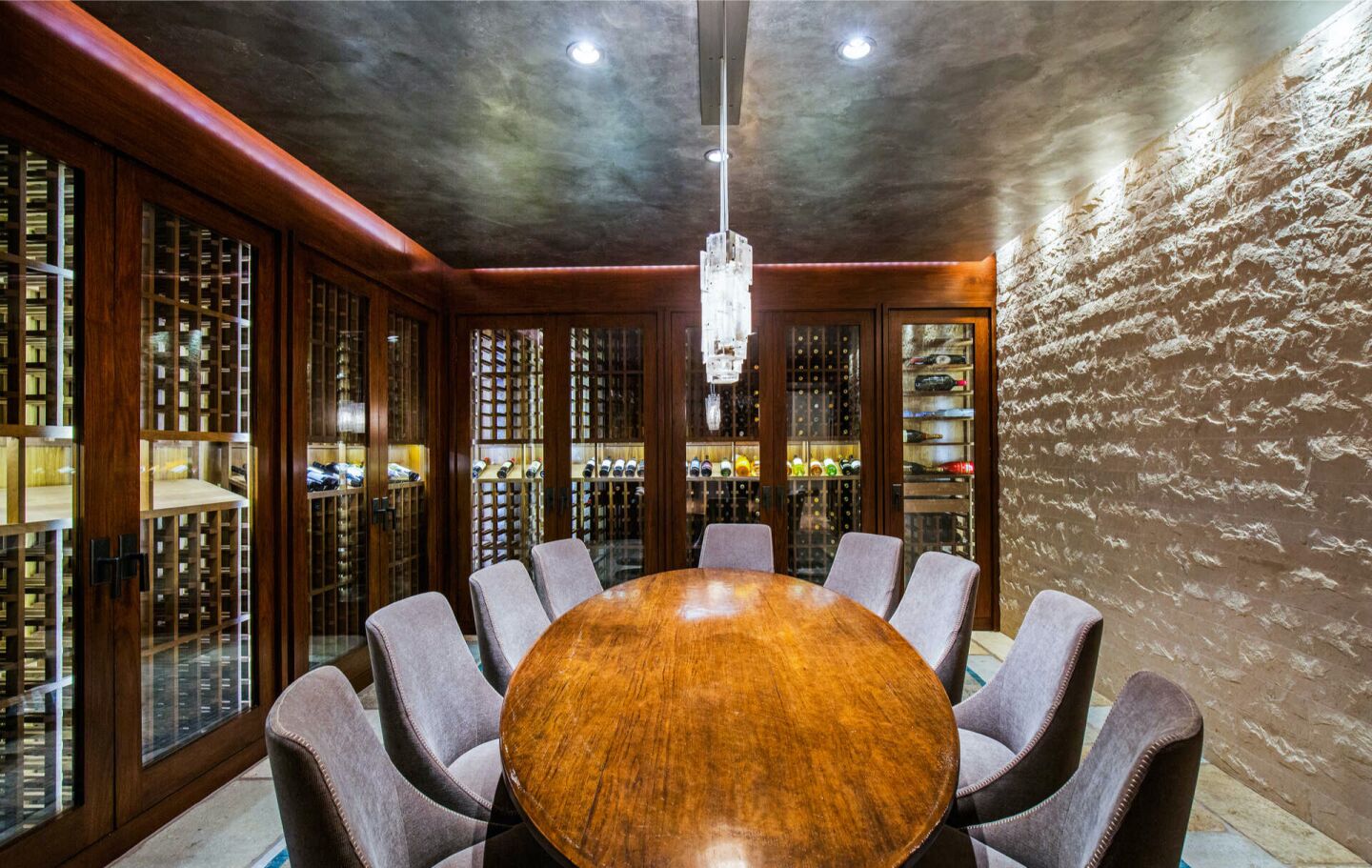 The wine cellar with a table surrounding by chairs.