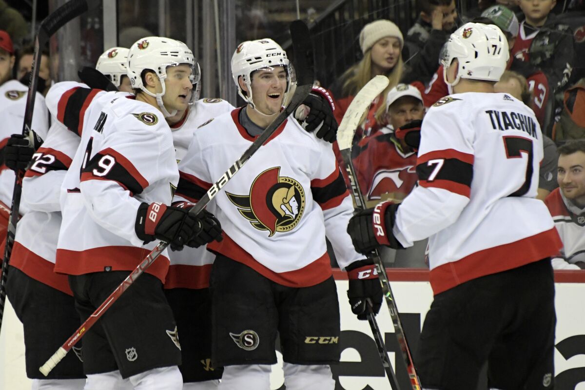 Ottawa Senators right wing Drake Batherson (19) celebrates his goal with teammates during the second period of an NHL hockey game against the New Jersey Devils, Monday, Dec. 6, 2021, in Newark, N.J. (AP Photo/Bill Kostroun)