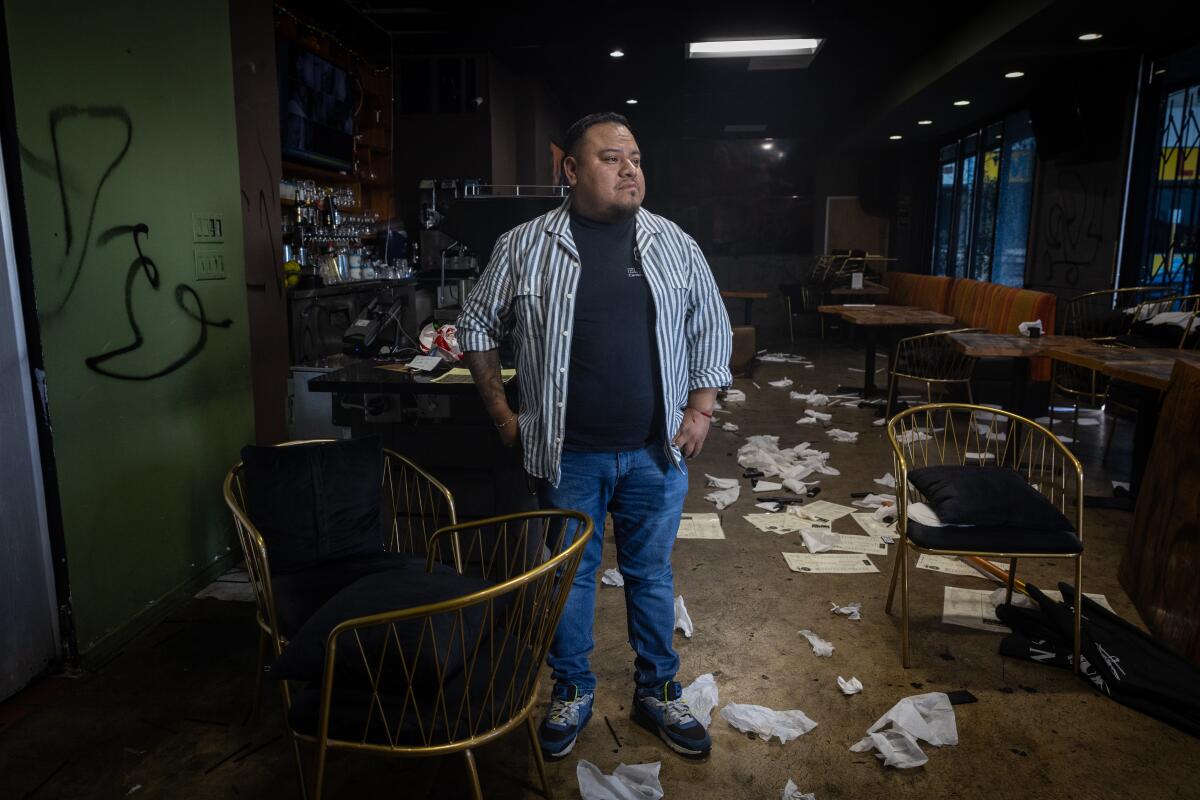 Владелец Бето Мендес стоит внутри разрушенного вандалами ресторана.