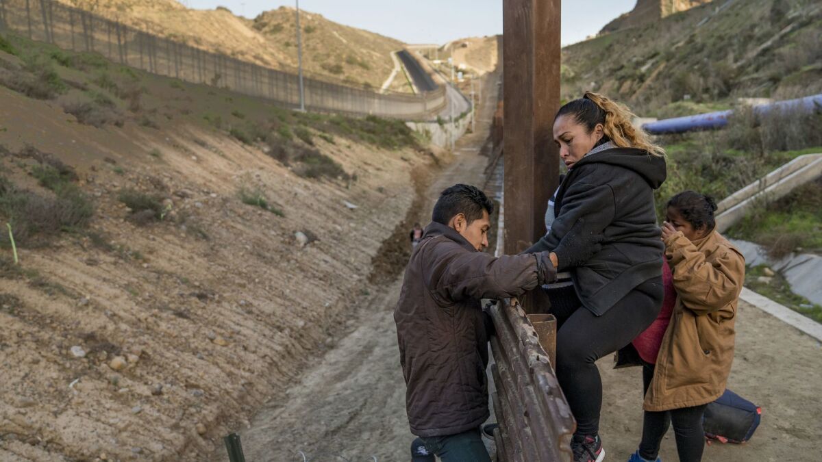 A pregnant migrant climbs the border fence before jumping into the U.S. to San Diego.
