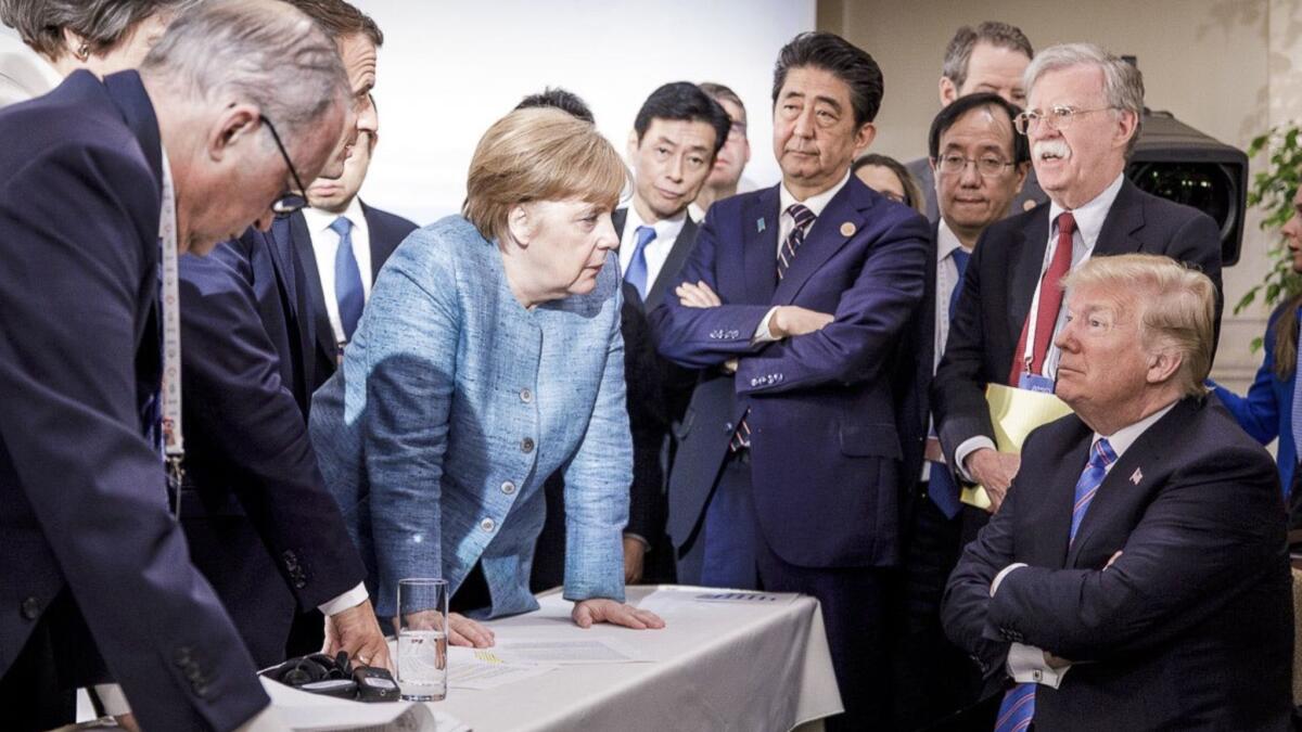 German Chancellor Angela Merkel, center, speaks with U.S. President Donald Trump during the G7 Leaders Summit in La Malbaie, Quebec, Canada.