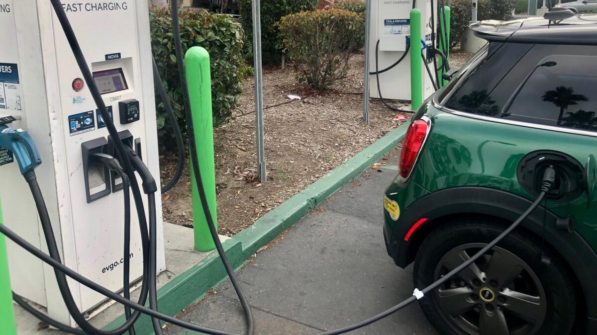 An electric vehicle charges its battery at a public station