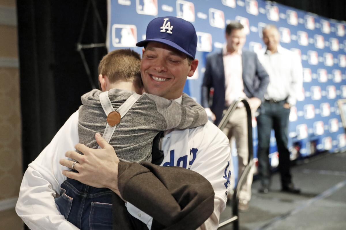 Rich Hill hugs his son Brice, 5, after the pitcher's new three-year deal with the Dodgers was announced at Major League Baseball's winter meetings on Dec. 5. (Alex Brandon / Associated Press)
