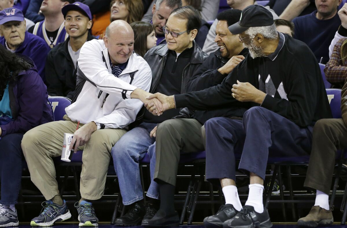 Steve Ballmer, left, shakes hands with former NBA players Bill Russell, right, and "Downtown" Freddie Brown.