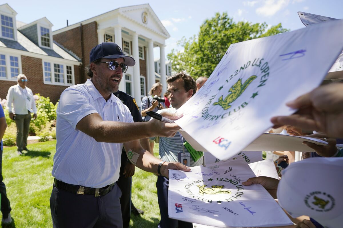 Phil Mickelson signs autographs after a practice round for the U.S. Open golf tournament at The Country Club, Wednesday, June 15, 2022, in Brookline, Mass. (AP Photo/Robert F. Bukaty)