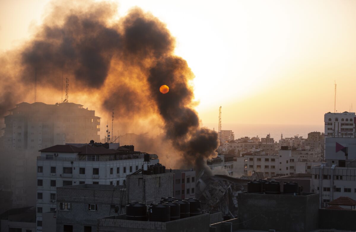 Smoke blocks out the sun above a collapsed building in Gaza