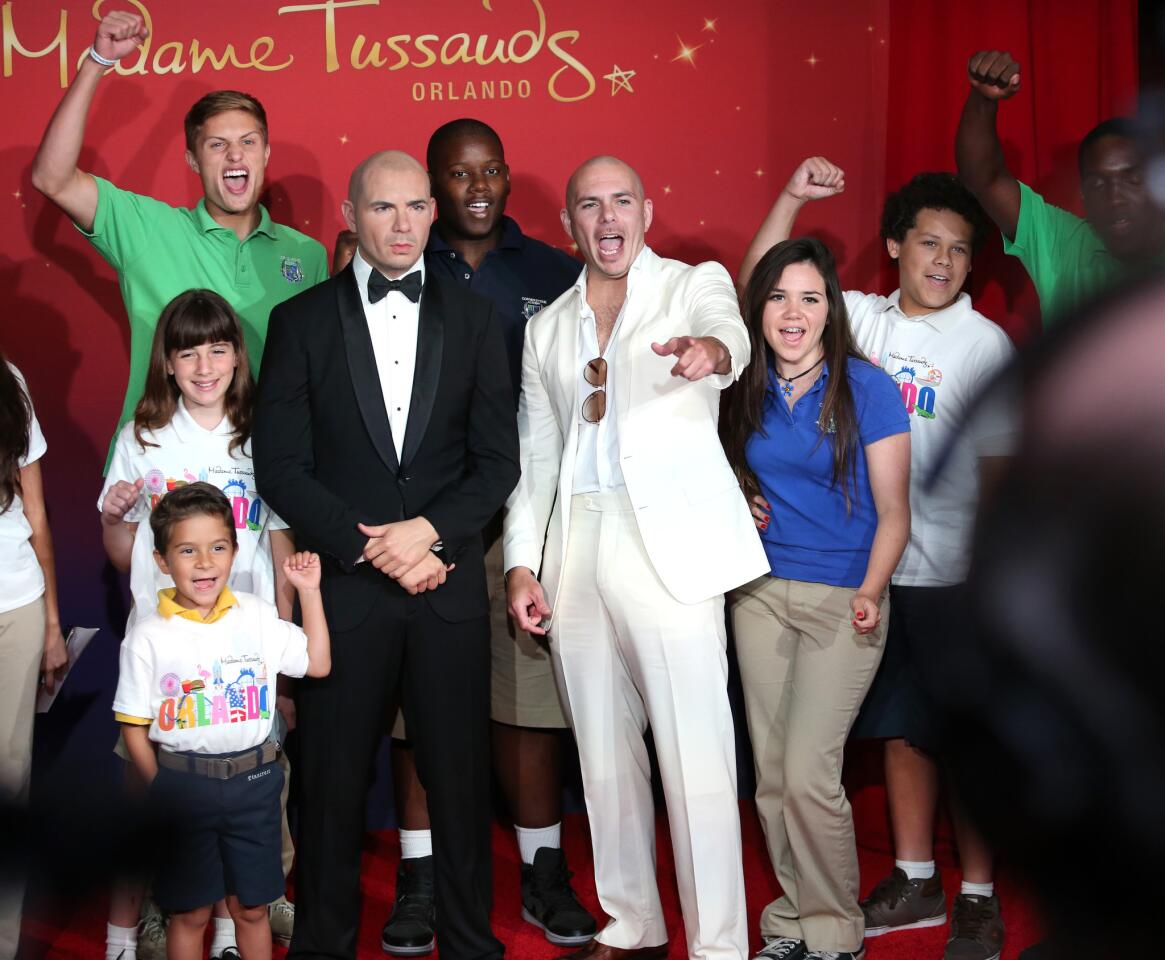 Rapper Pitbull cheers with young fans after his double is revealed at Madame Tussauds Orlando wax musuem at the i-Drive 360 complex, in Orlando, Fla., Friday, May 29, 2015. The attraction features life-sized replicas of famous people from television, music, movies, sports, politics and history. ( Joe Burbank/Orlando Sentinel)