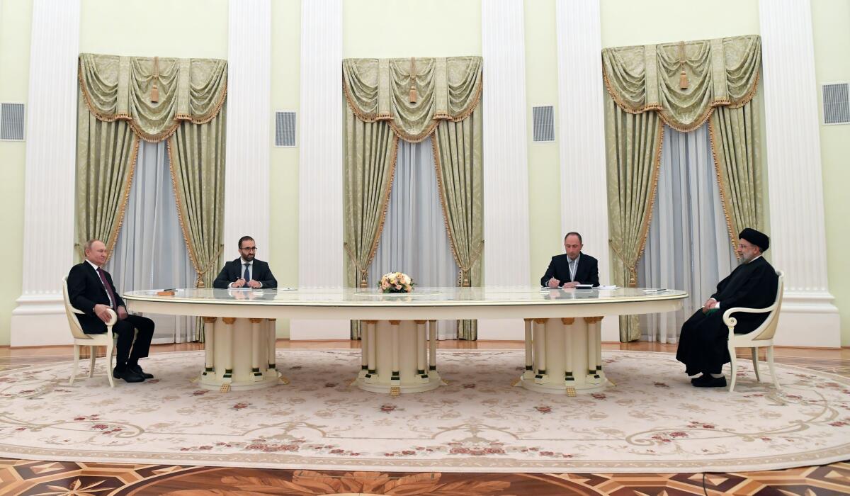 Russian President Vladimir Putin, left, and Iranian President Ebrahim Raisi, right, talk to each other during their meeting in the Kremlin in Moscow, Russia, Wednesday, Jan. 19, 2022. (Pavel Bednyakov, Sputnik, Kremlin Pool Photo via AP)