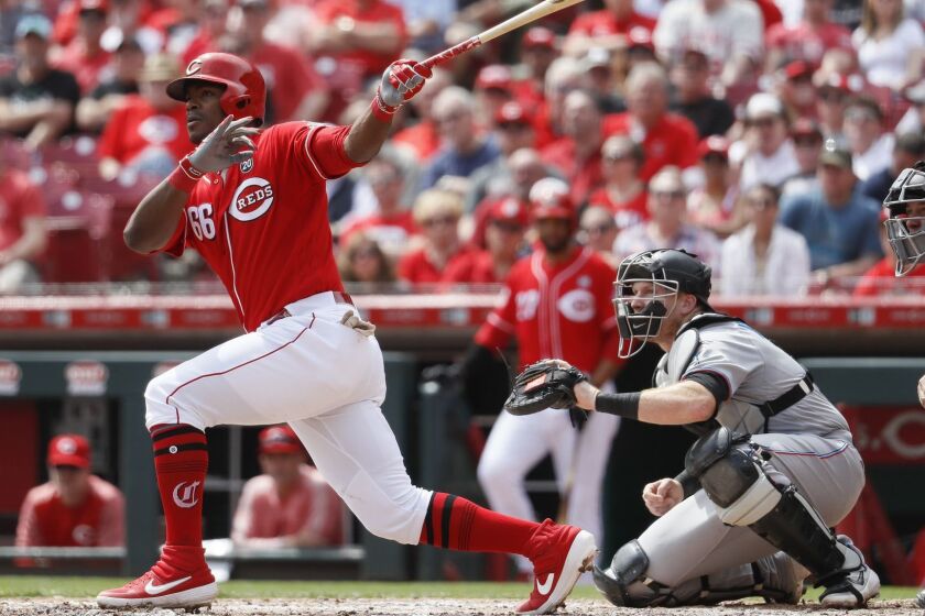Cincinnati Reds' Yasiel Puig hits a two-run double off Miami Marlins starting pitcher Pablo Lopez in the fifth inning of a baseball game, Thursday, April 11, 2019, in Cincinnati. (AP Photo/John Minchillo)