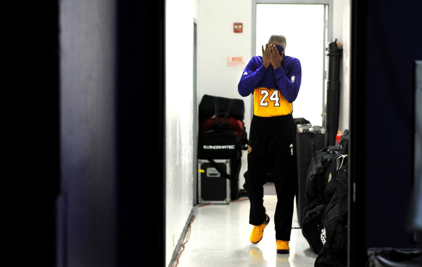 Kobe Bryant wipes his face as he leaves the Sleep Train Arena locker room at halftime during a Lakers game against the Kings in Sacramento on Jan. 7, 2016.