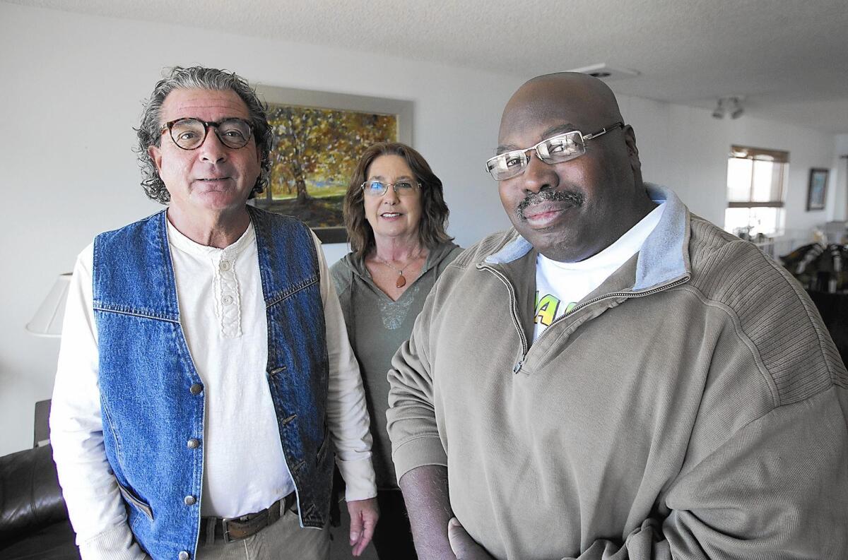 Pastor Don Sciortino, left, and his wife, Karen, with Walter Randolph in their Laguna Beach home.