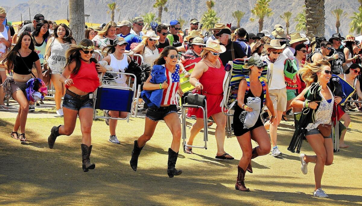 Country music fans dash across the Empire Polo Club fields to reserve the best viewing spots as the gates open on the opening day of the Stagecoach Country Music Festival.