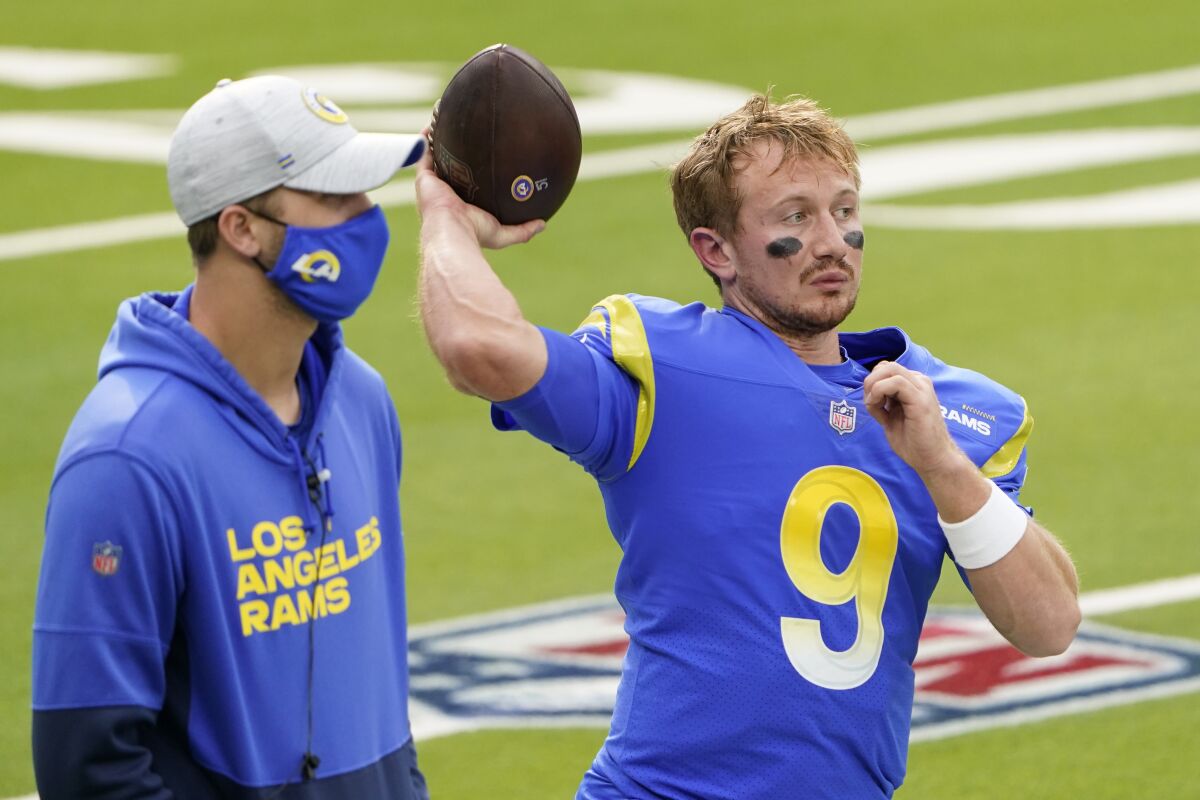 Injured Rams quarterback Jared Goff stands next to John Wolford (9) before a game in January 2021.