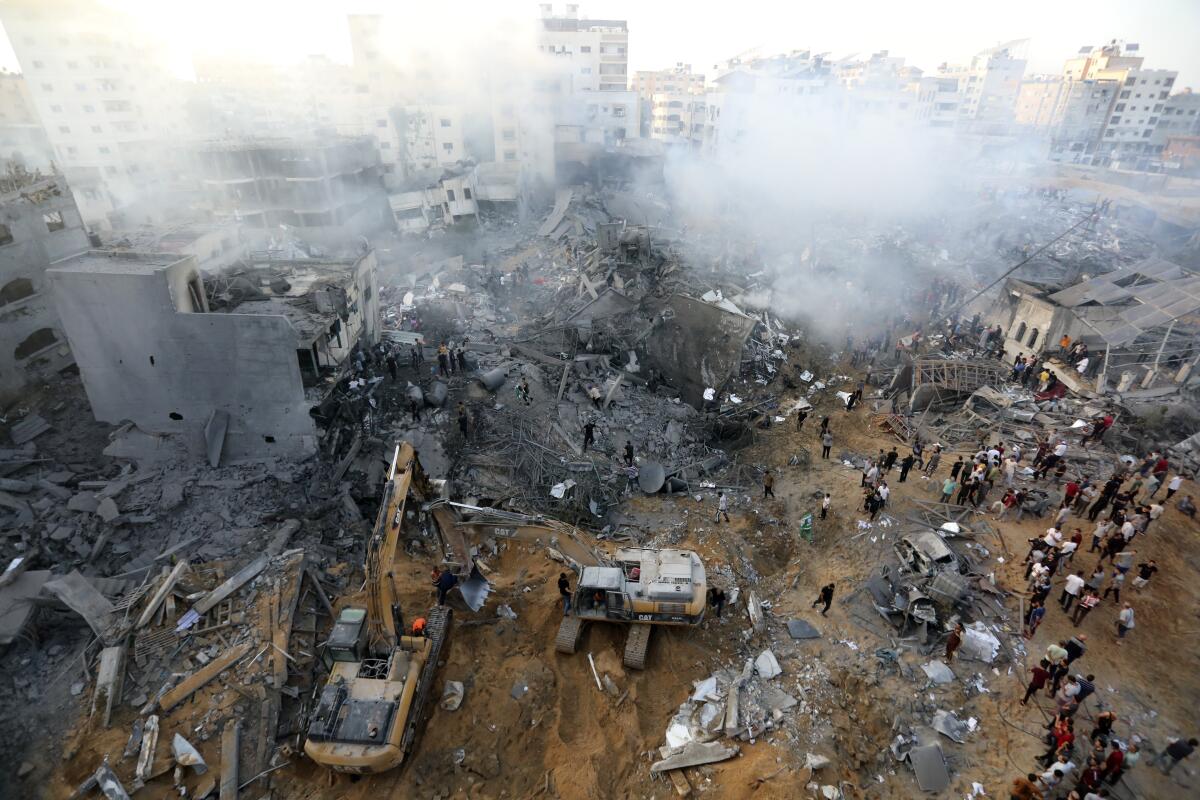 Palestinos inspeccionan los daños de edificios destruidos tras ataques aéreos sobre Ciudad de Gaza