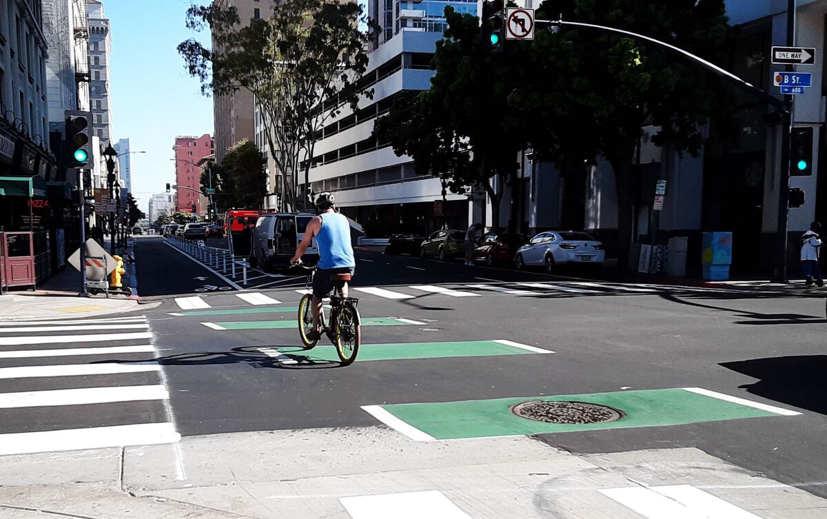 A bike rider uses new bike lanes downtown.