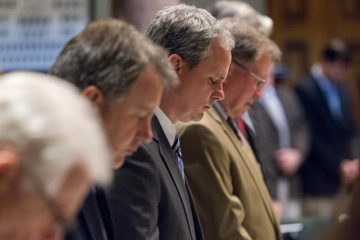 Tennessee state senators bow their heads during the prayer before the Senate floor session in Nashville on Thursday.