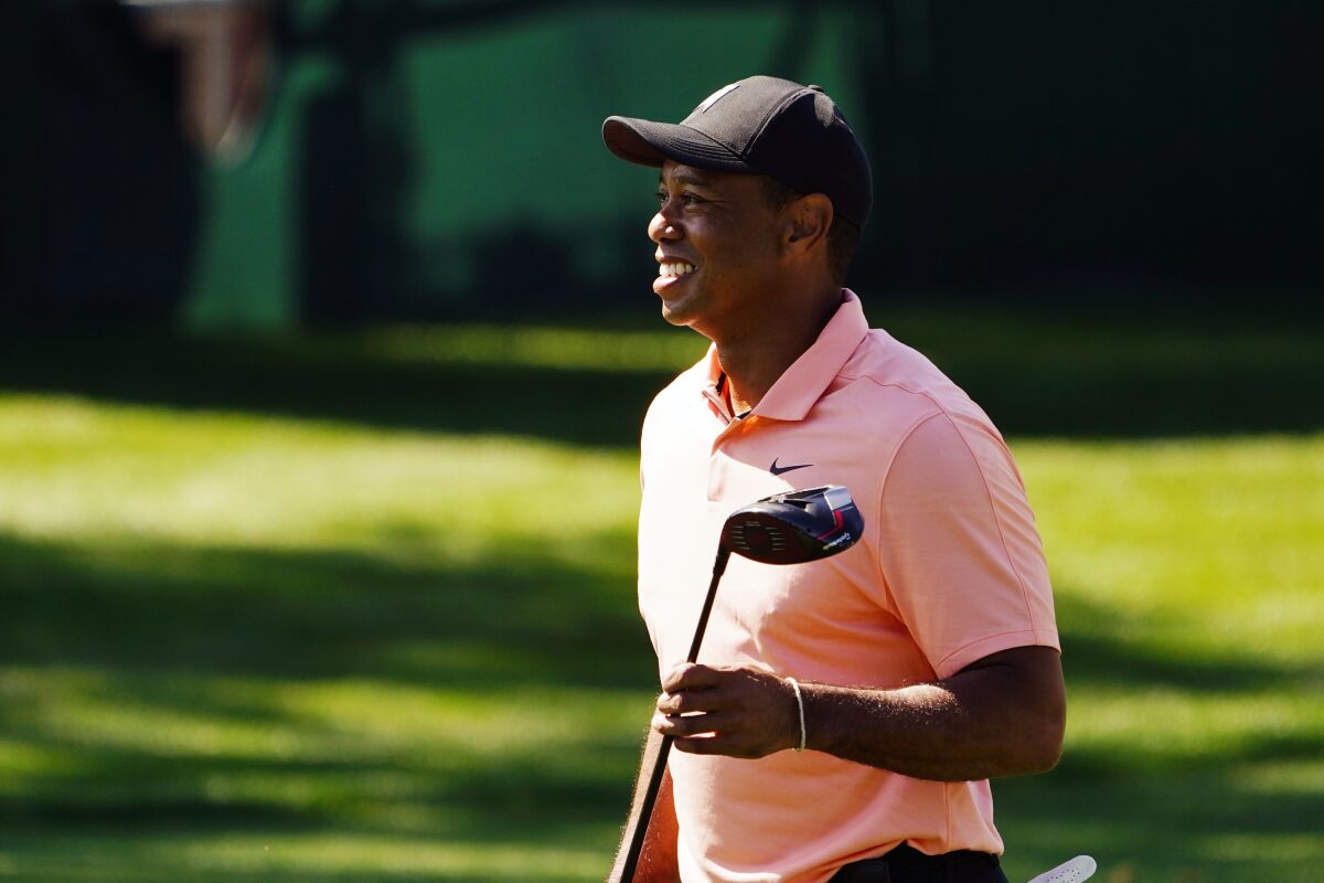 Tiger Woods smiles as he leaves the driving range during practice before the Masters golf tournament, Sunday, April 3, 2022, in Augusta, Ga. (AP Photo/Matt Slocum)