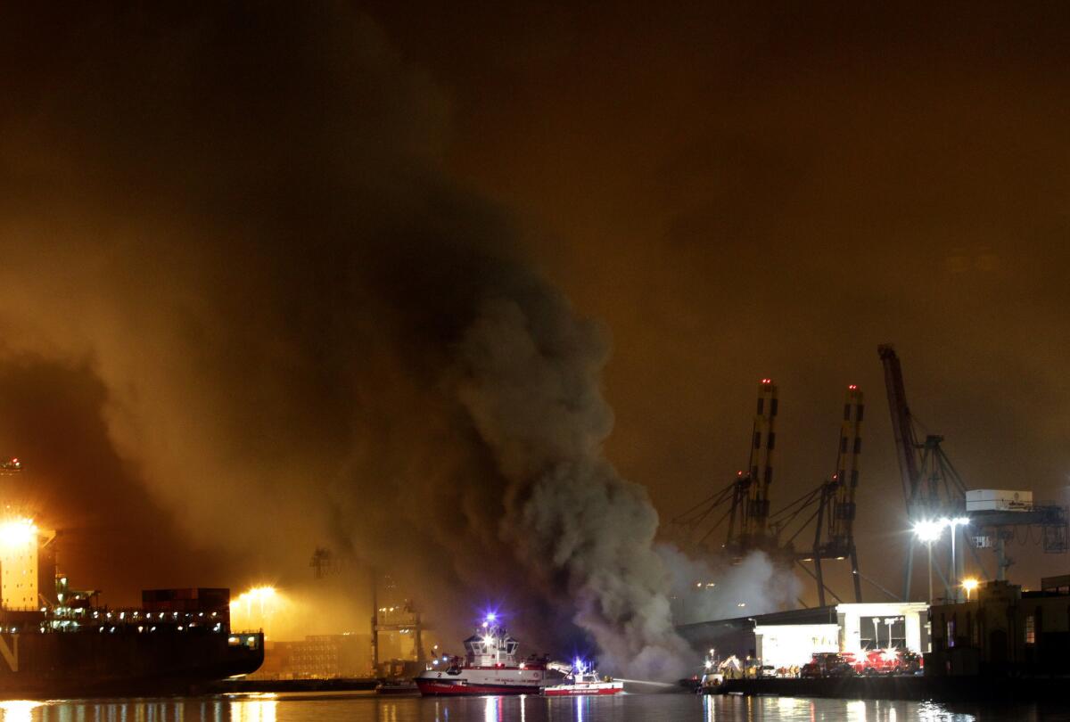 Thick billowing smoke rose to cover the port of Los Angeles in San Pedro Monday night as Los Angeles city fireboats played their streams of water onto the fire which broke out near berths 177 and 179.